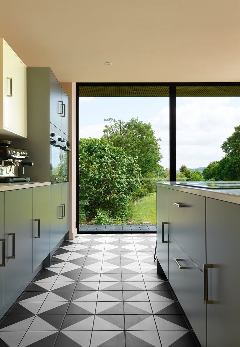 Black and white floor tiles laid in a diamond pattern with oak wood flooring