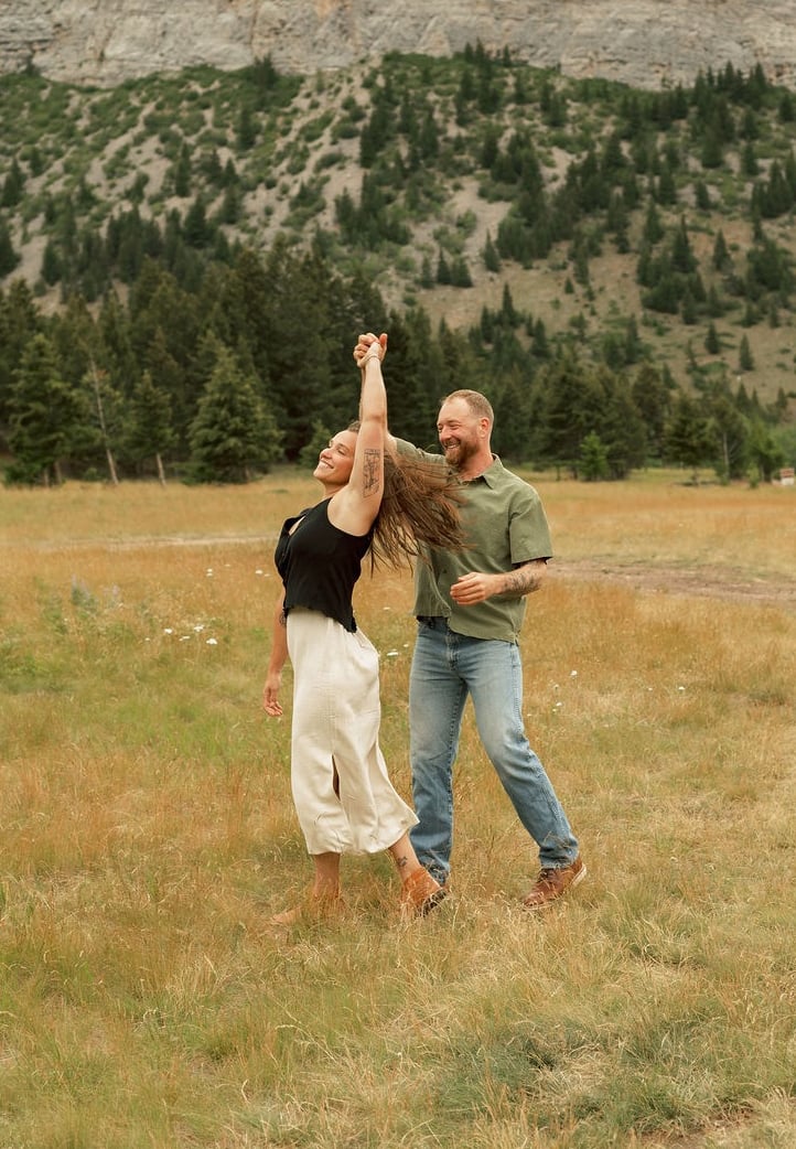 a man and woman are playing with a kite