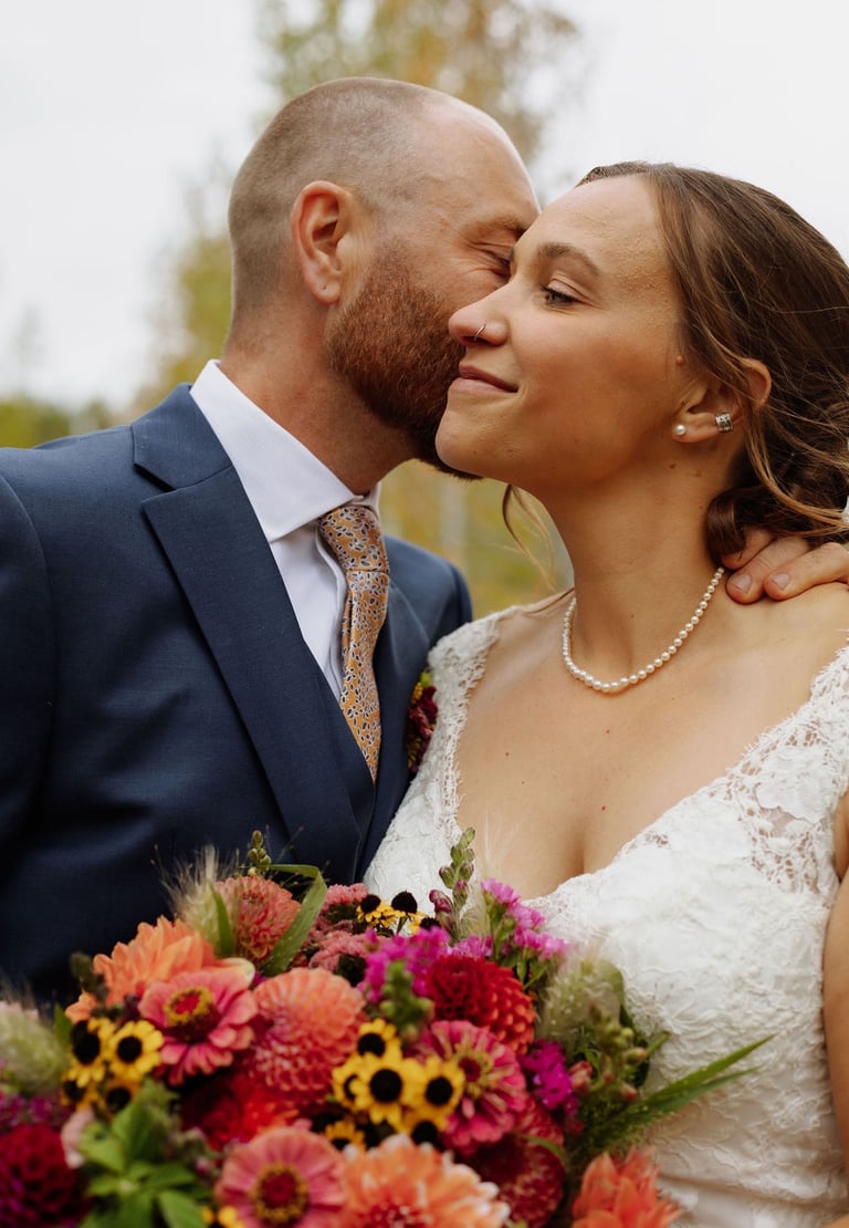 a bride and groom kissing in a field