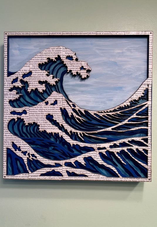 laser cut and painted three dimensional wooden ocean wave cresting with whitecaps made of book pages
