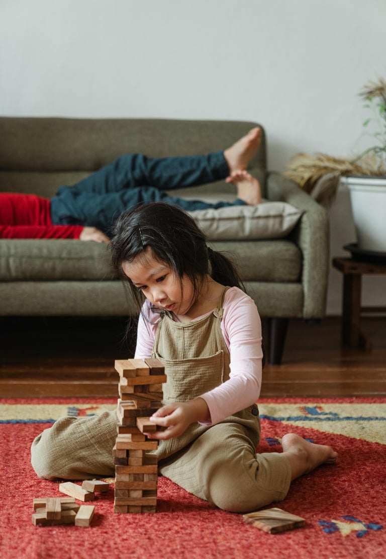 petite fille en train de construire une tour de cubes