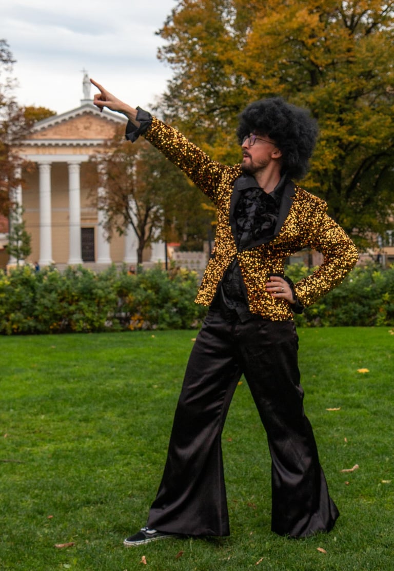 Blizgus aukso spalvos švarkas,juodos kelnės ir juodi marškiniai