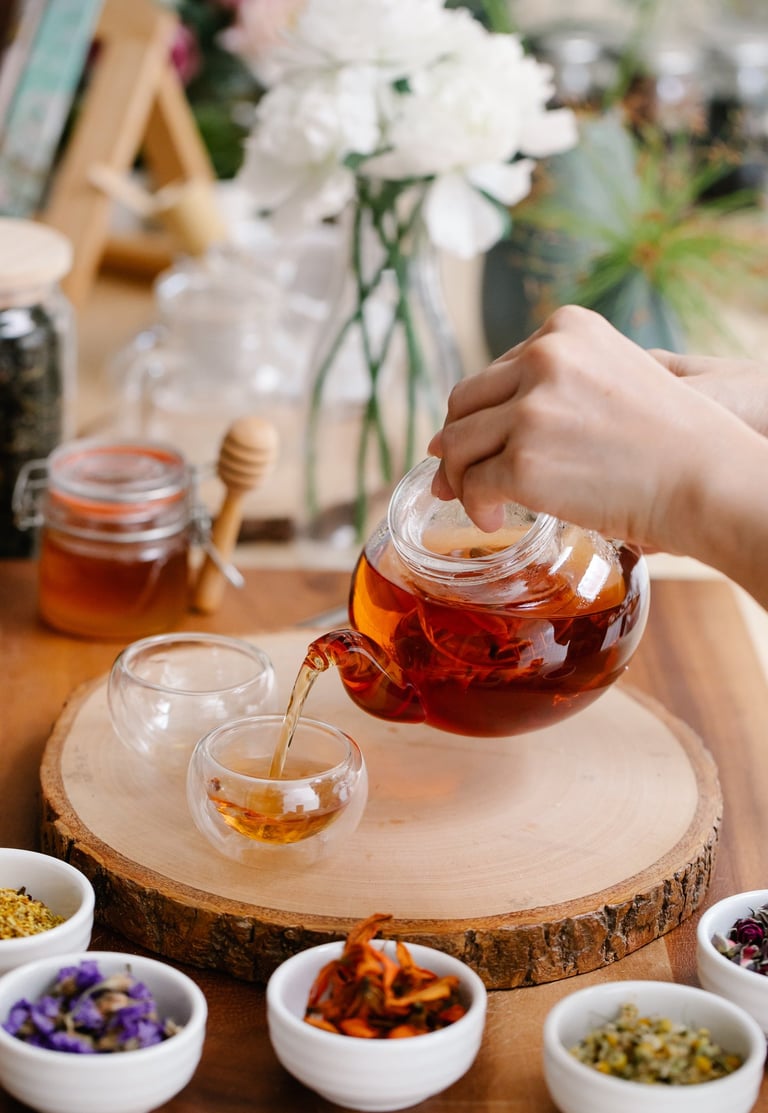 Woman brewing herb tea and white flowers on the table