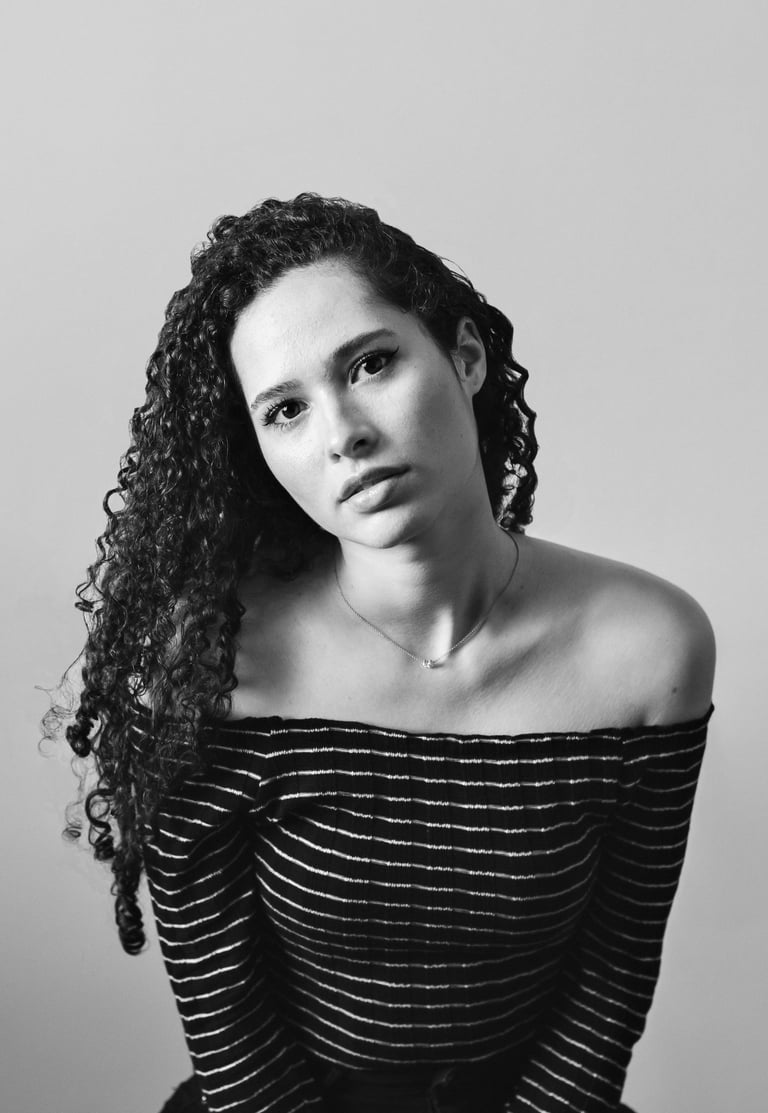Black and white fine art portrait of a woman with curly hair and calm gaze