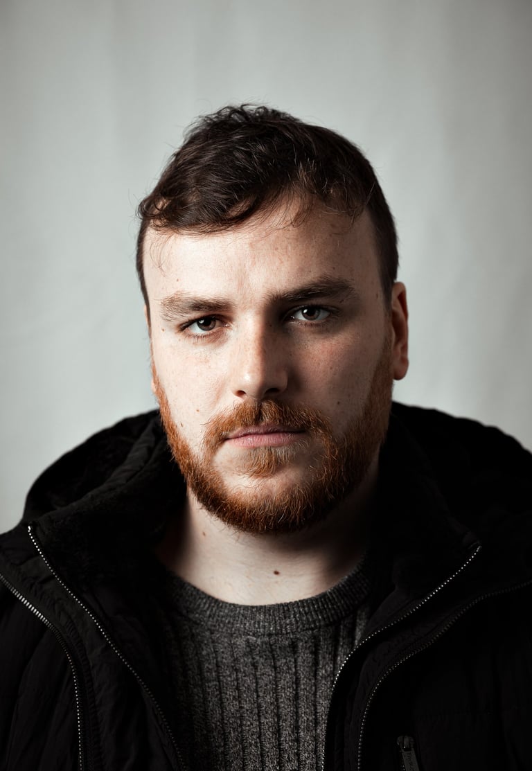 Fine art close-up portrait of a man with intense gaze and soft natural light