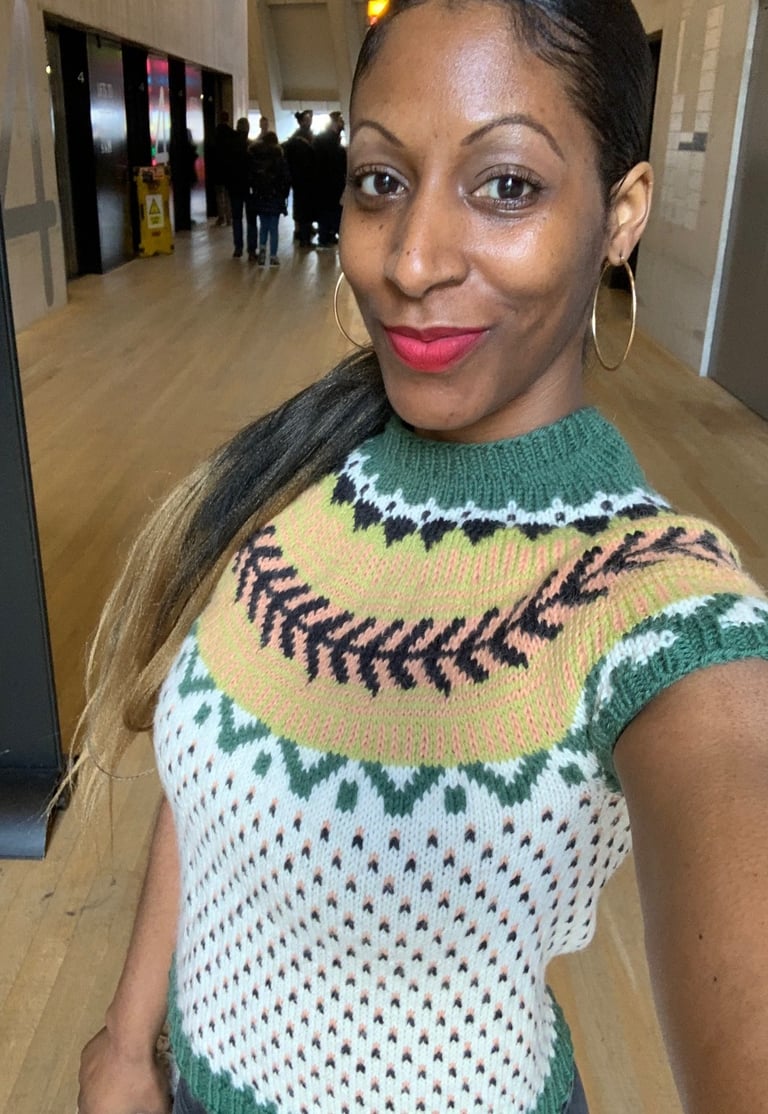A woman in a knitted sweater with fair isle pattern stitch. She is Tate Modern museum in London