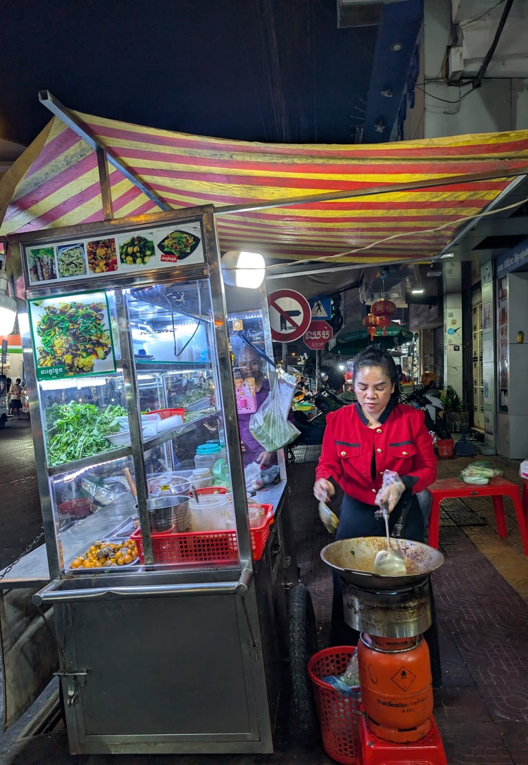 a street food vendor stir frying frog in Phnom Penh, Cambodia