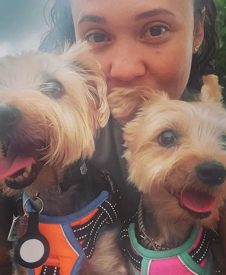 a woman holding two dogs in her arms