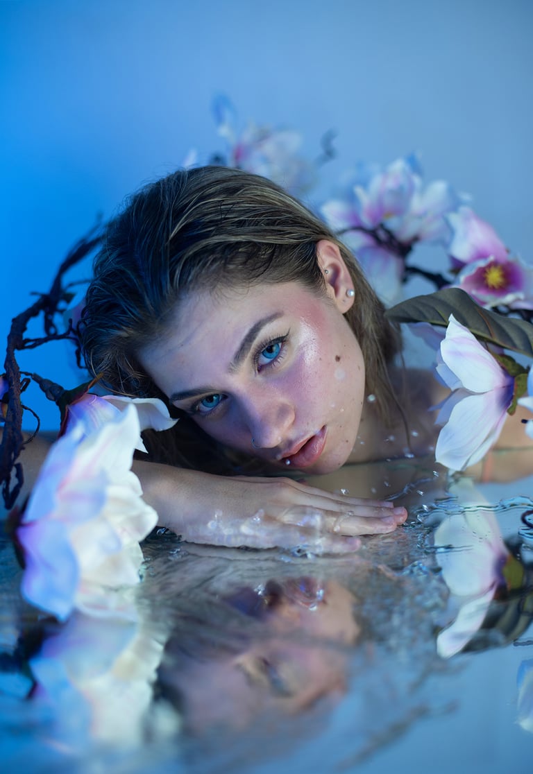 Sesión creativa de modelo rubia maquillada como sirena, con flores y espejo