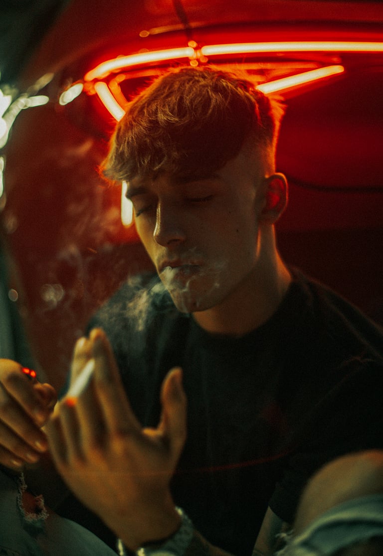 Modelo fumando en un coche Seat León rojo en un parking oscuro