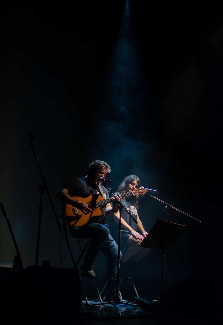 a man and woman playing guitar together on stage