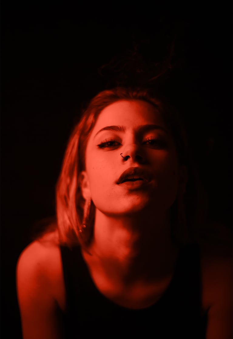 Fotografía de actriz en fondo oscuro con detalles de luz roja, sesión inspirada en el cine español