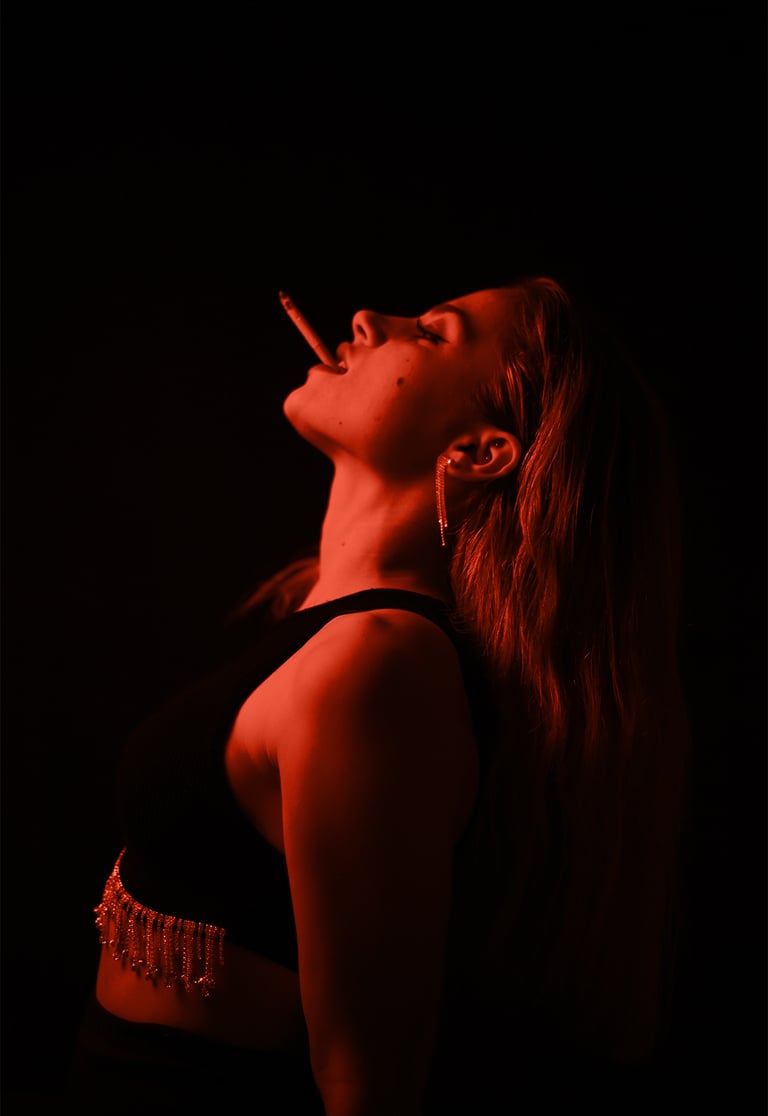 Fotografía de actriz en fondo oscuro con detalles de luz roja de estilo cinematgráfico
