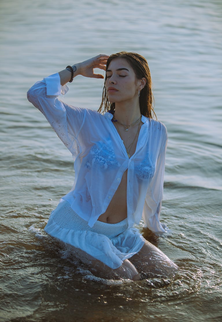 Sesión de fotos de revista con modelo en la playa al amanecer, vestido blanco y bikini