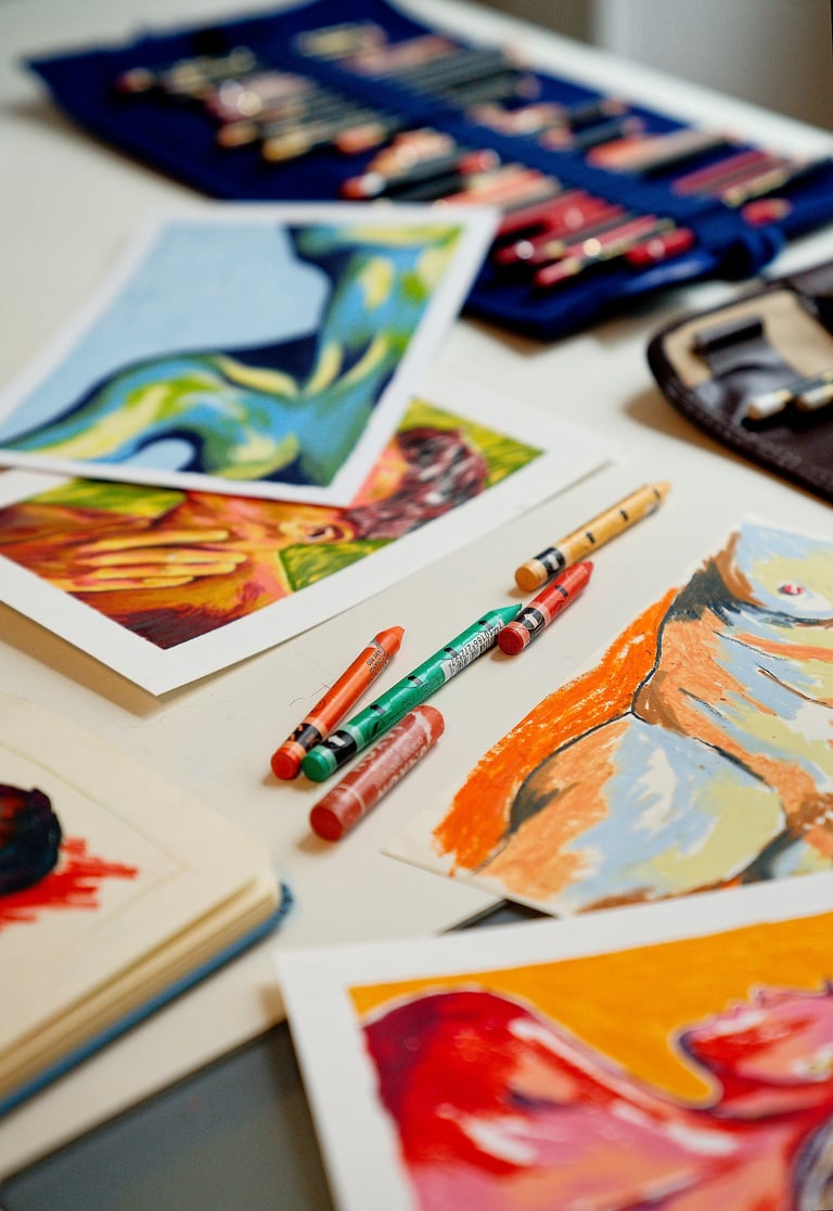 a table with a bunch of art work on it
