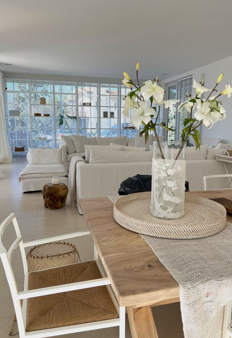 a table with a vase of flowers in a living room