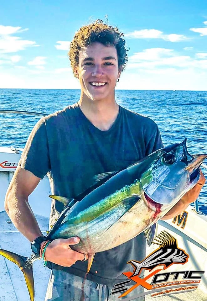a man holding a fish on a boat