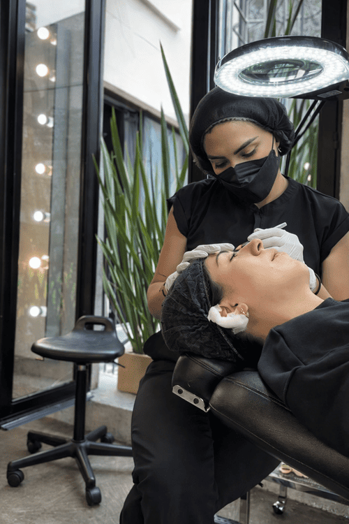 Espexialista en micropigmentacion trabajando en la ceja de una clienta