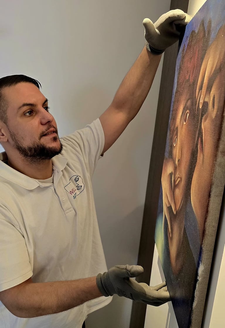 un employé de Well Art accroche un tableau