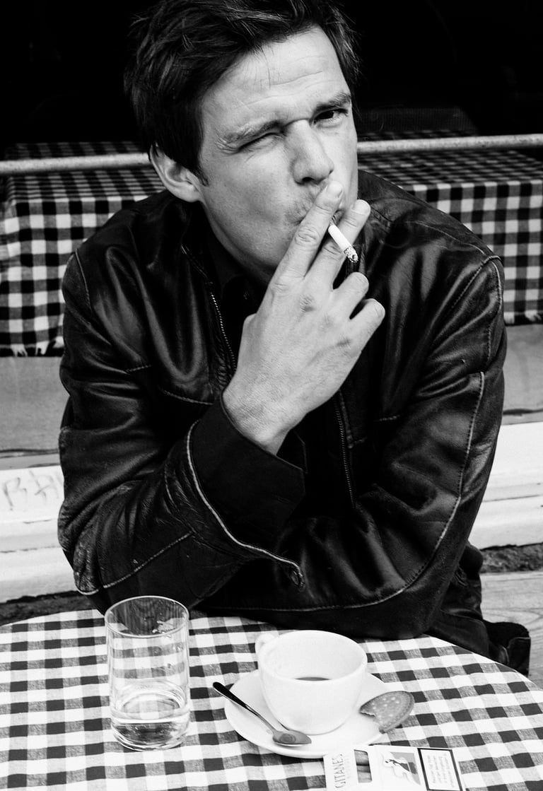 Detlef Cooper sitting by a table with a coffee cup.