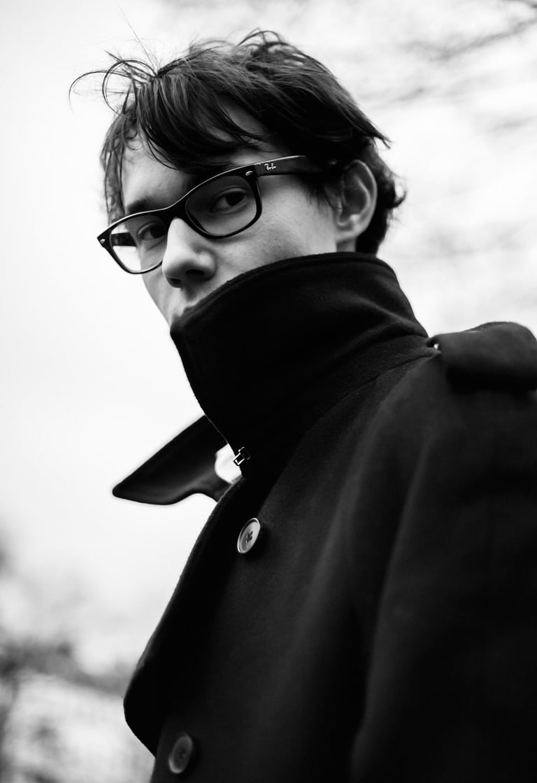 Portrait of filmmaker Emile Rafael wearing a coat.