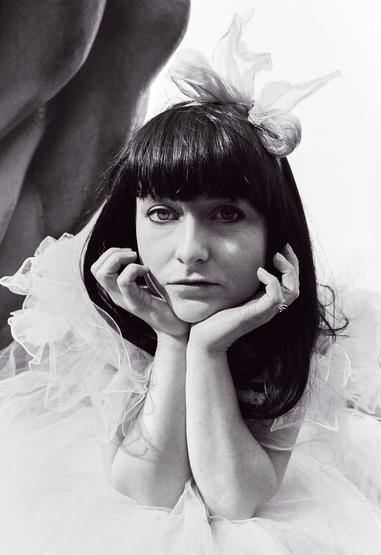 A brunette wearing a bow in an 80s prom dress.