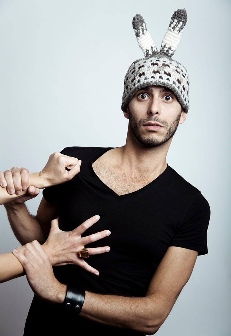 A man with a funny hat with ears being pulled by a woman.