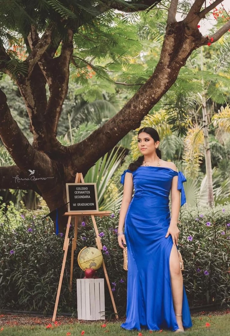 una adolescente con vestido azul celebrando la graduación de su preparatoria