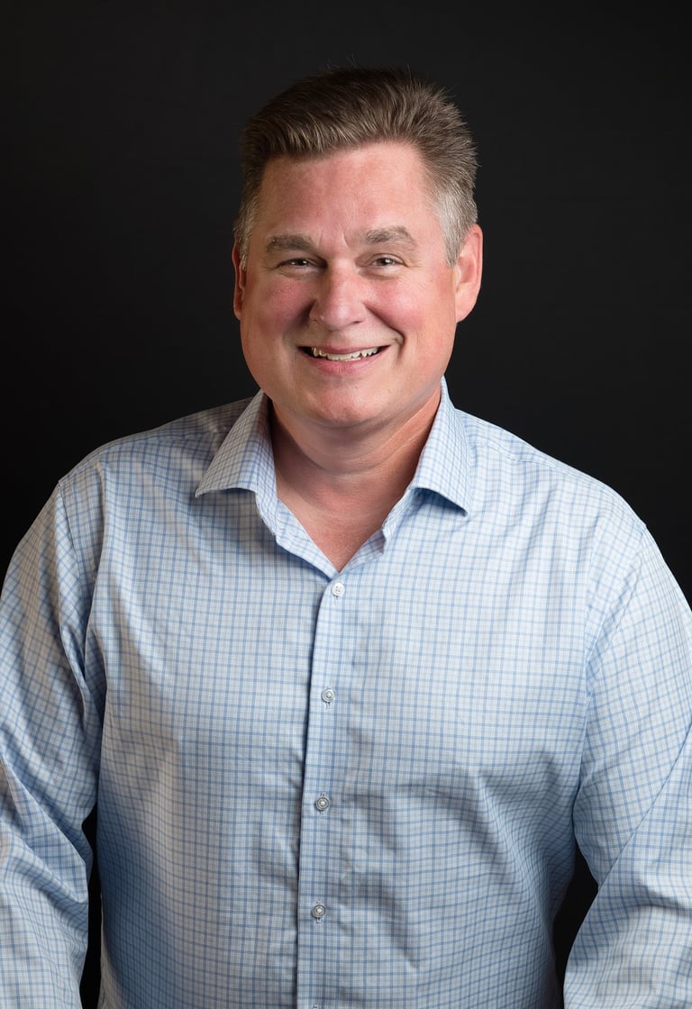 a man in a blue shirt and a white shirt smiling