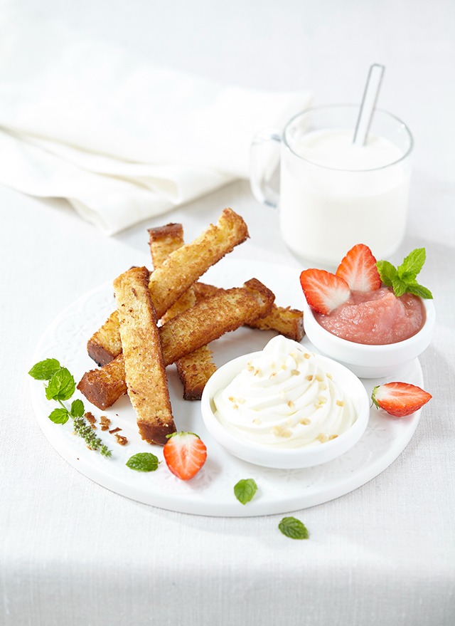 a plate with a bowl of strawberries and a glass of milk