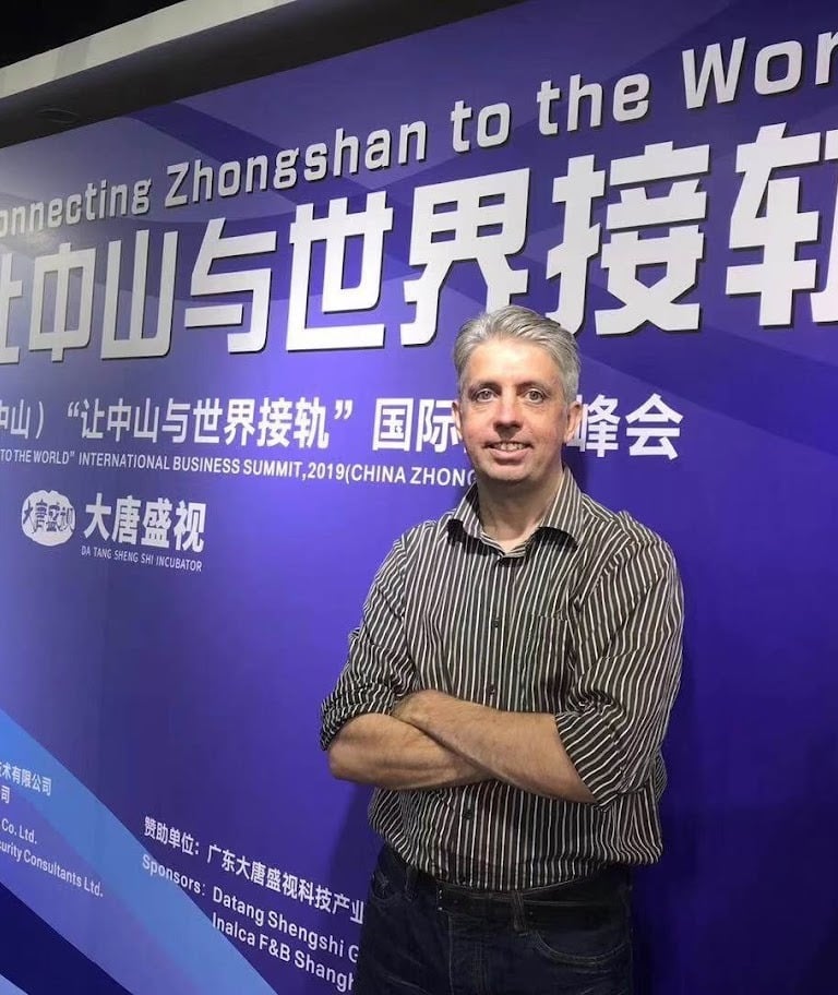 a man standing in front of a sign that says,'welcome to the world