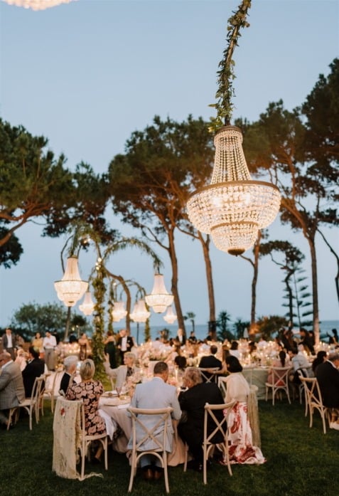 Elegant outdoor dinner at Villa El Rincon with chandeliers and guests under the trees