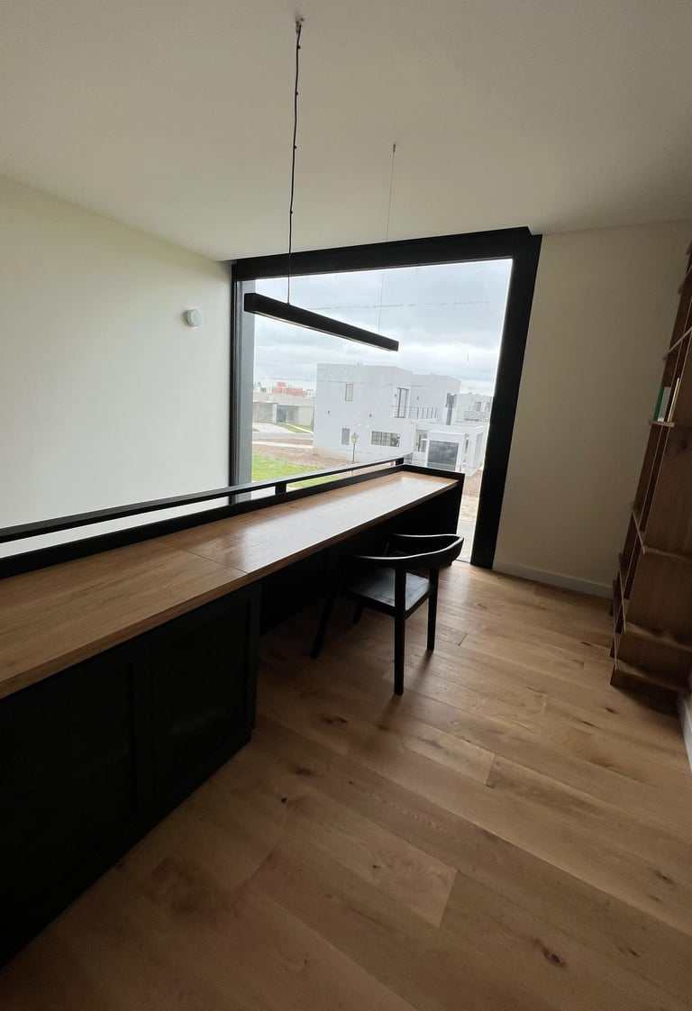  un escritorio con un escritorio con ventana y una silla