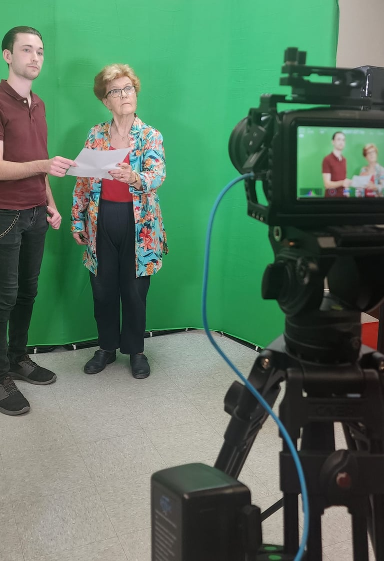 Participants learning on-camera performance techniques in a green screen filmmaking workshop
