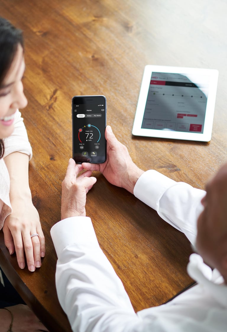 a man and woman sitting at a table with a tablet