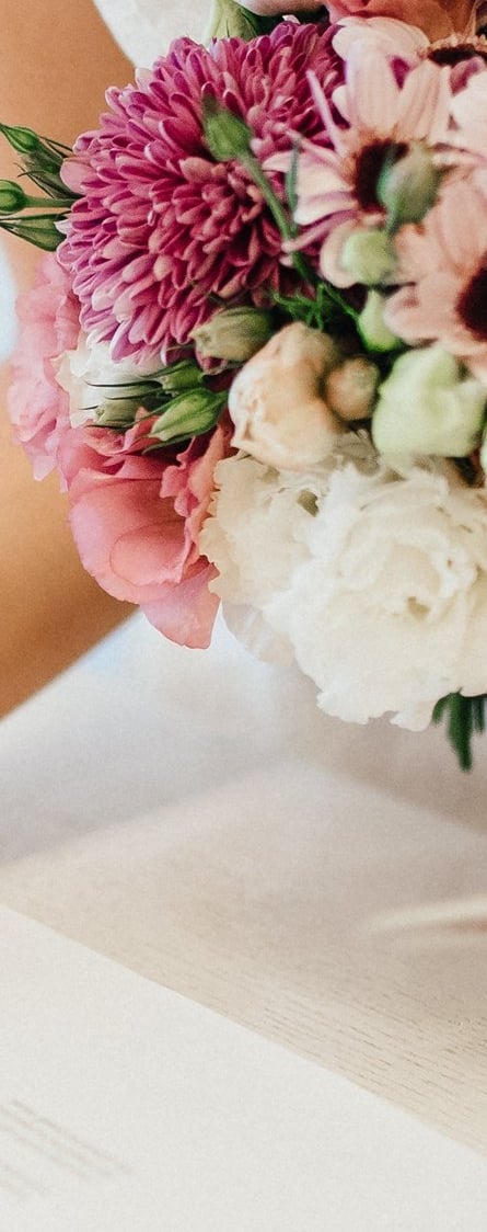 Bride signing the wedding register with bouquet—enquire to book your Glasgow wedding videographer.