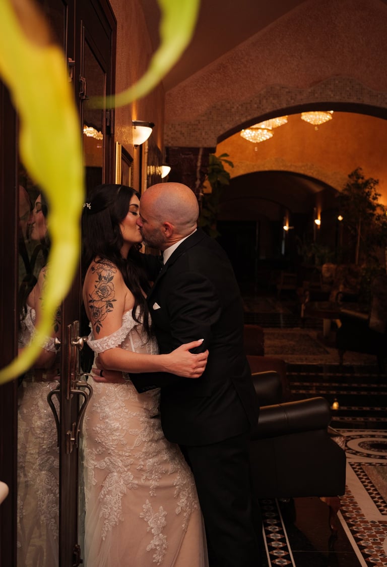 a wedding Couple kissing in a hotel lobby