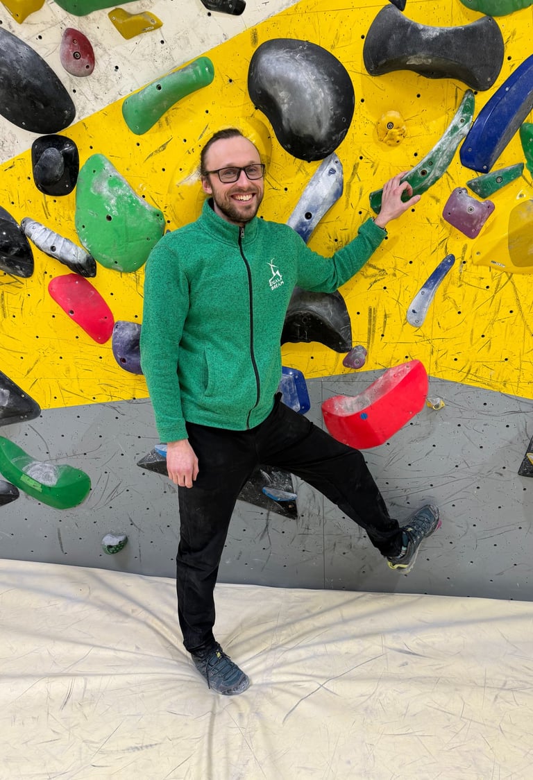 a man standing in front of a climbing wall