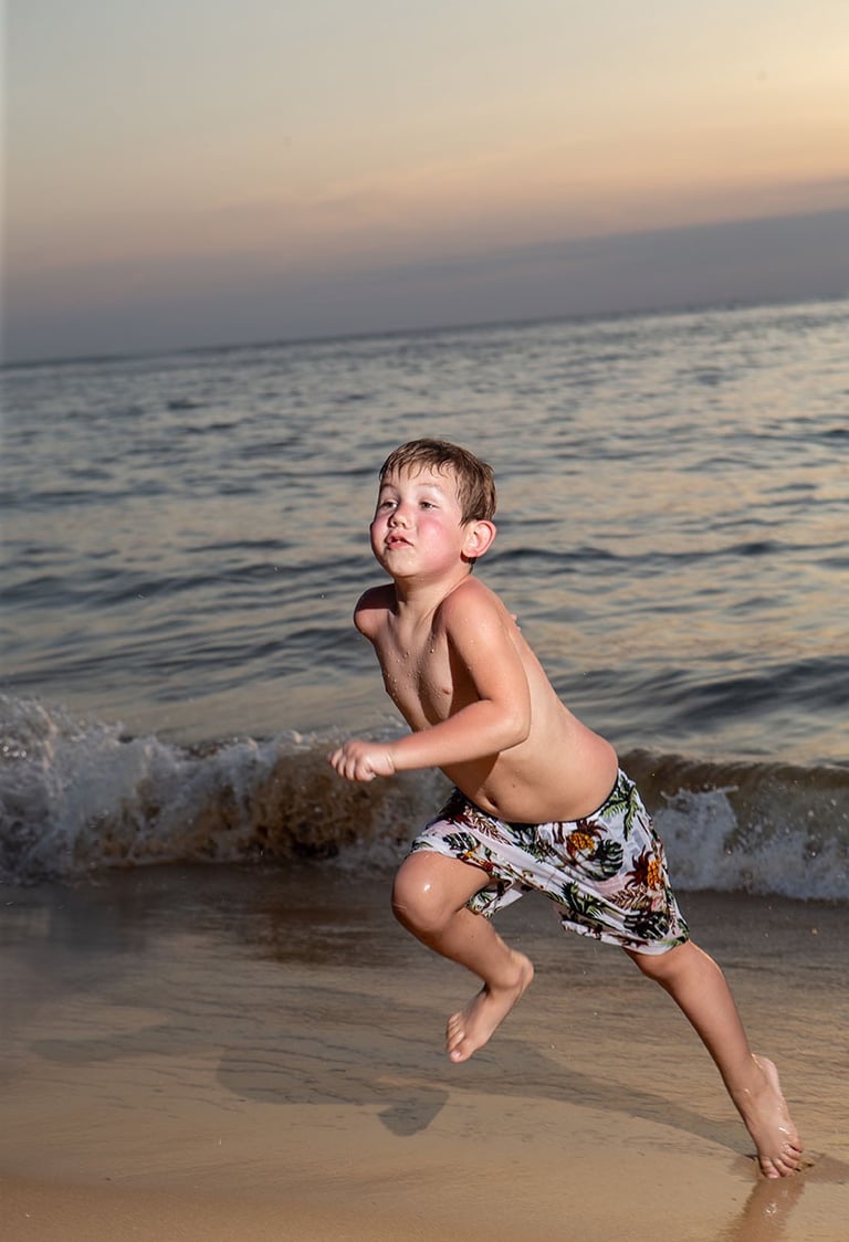 Ребенок бегает по пляжу на Фукуоке