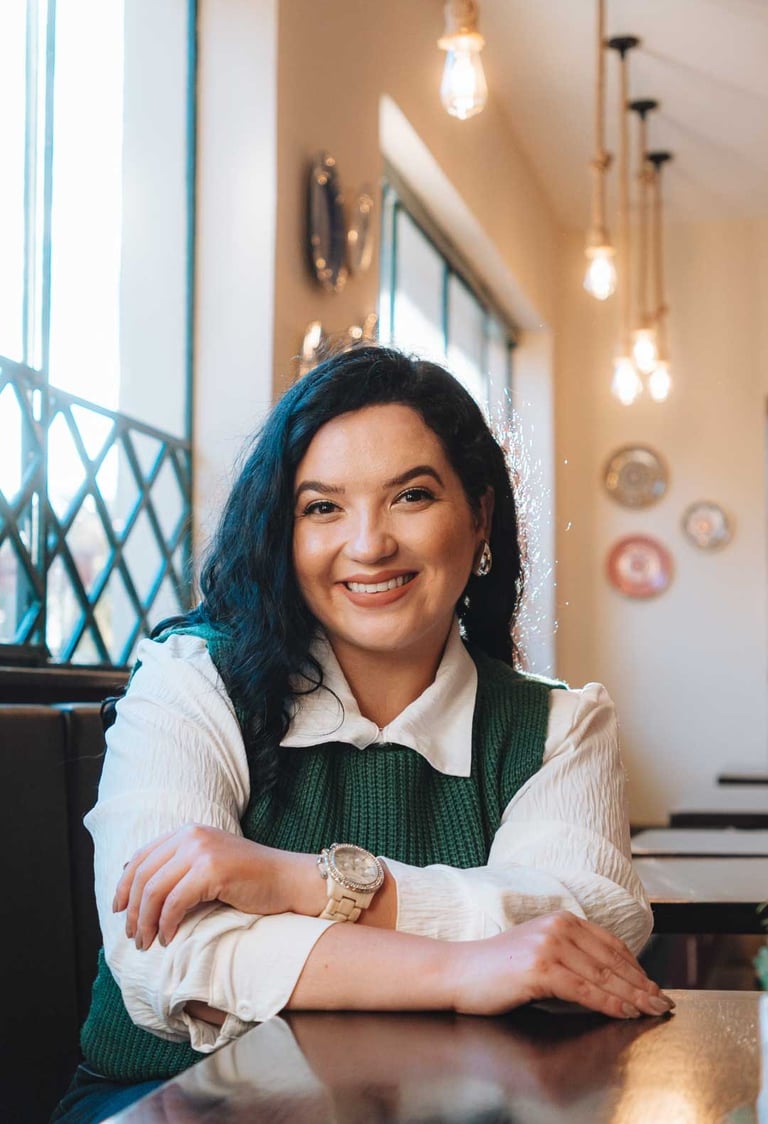 Raabe sorrindo com luzes pendentes ao fundo.