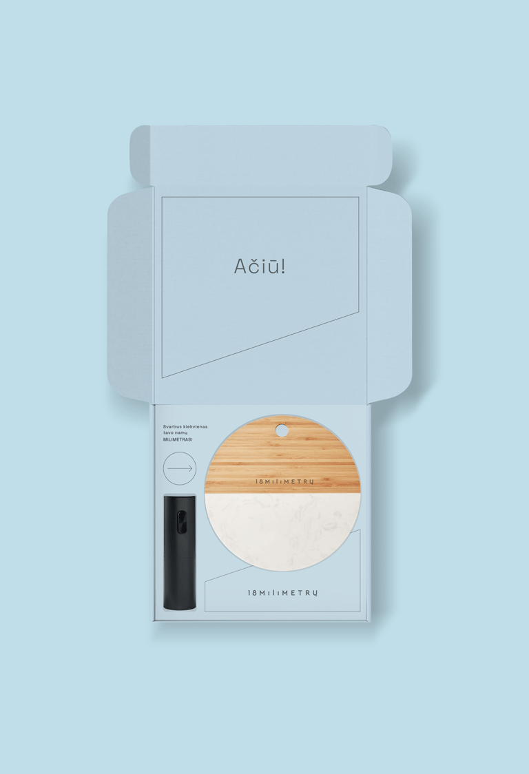Elegant light blue gift box containing a wooden and marble coaster and black accessory.