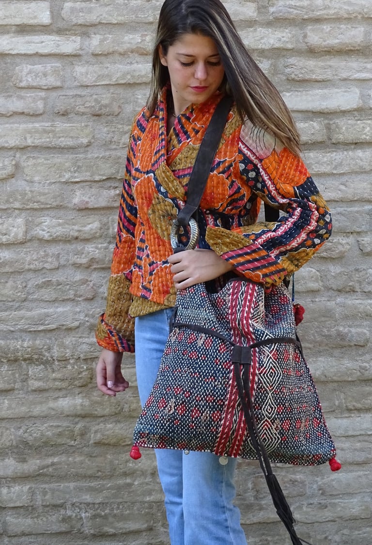 modella che indossa una borsa realizzata con un antico tessuto tribale