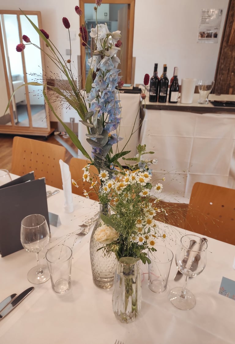 Margeriten und Rittersporn in Kristallvasen mit Goldrand