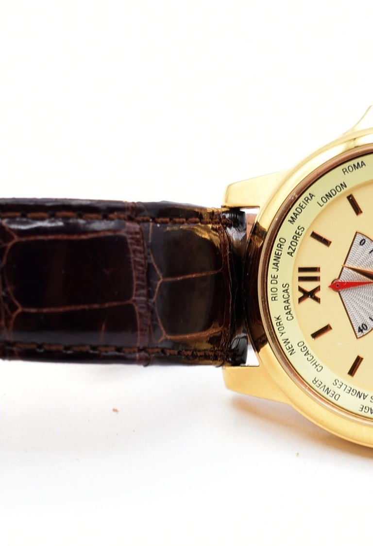 Luxury Nicolet gold world timer watch featuring a brown alligator leather strap.