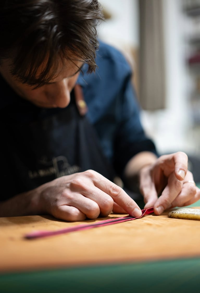 Le maroquinier assemble un jonc en cuir à la main