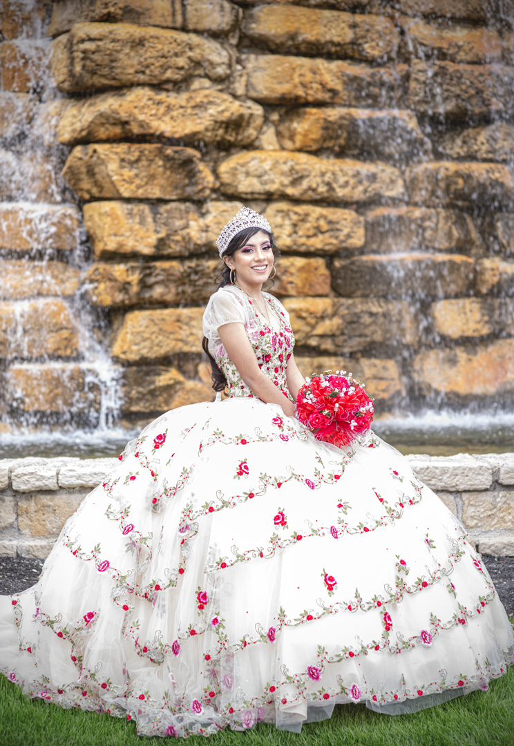 a woman in a white quinceanera dress with a bouquet of flowers