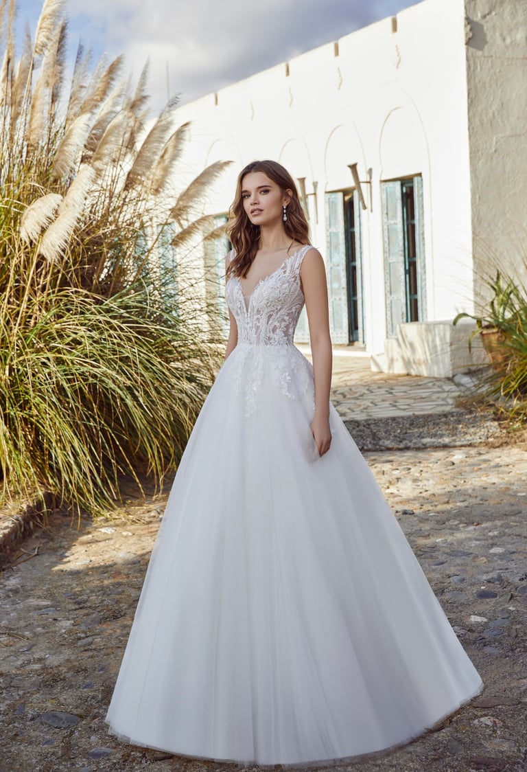 a woman in a white wedding dress standing in front of a house