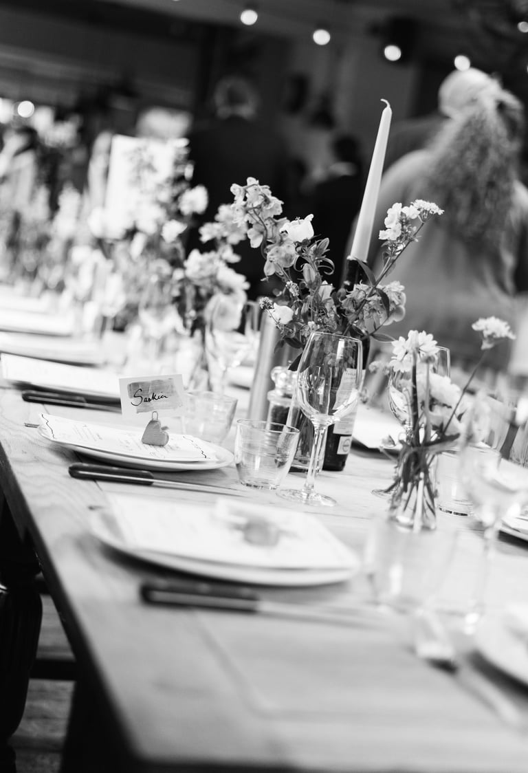 black and white image of a wedding table with candles and flowers