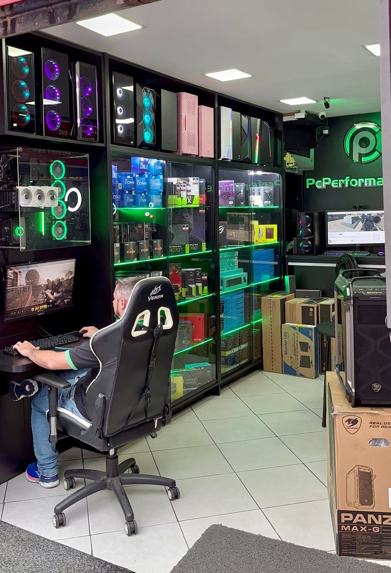 a man sitting at a desk with a computer monitor and a gaming chair