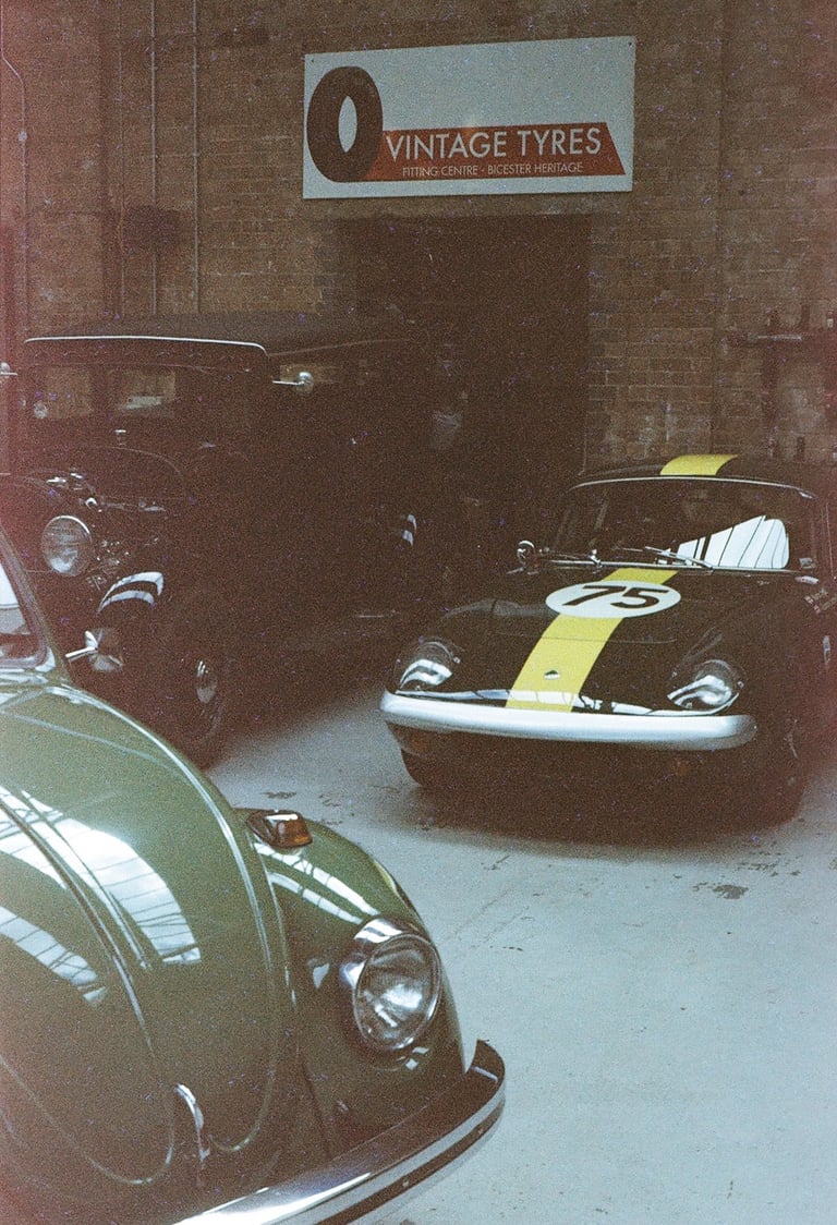 a classic car garage with three vintage cars parked in it